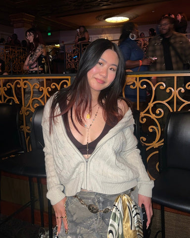 Woman posing in a dimly lit indoor setting with decorative elements